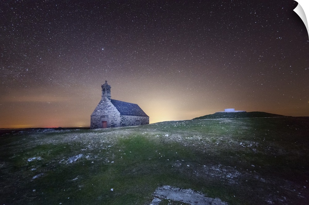 A church in a field in the evening with stars in the sky.