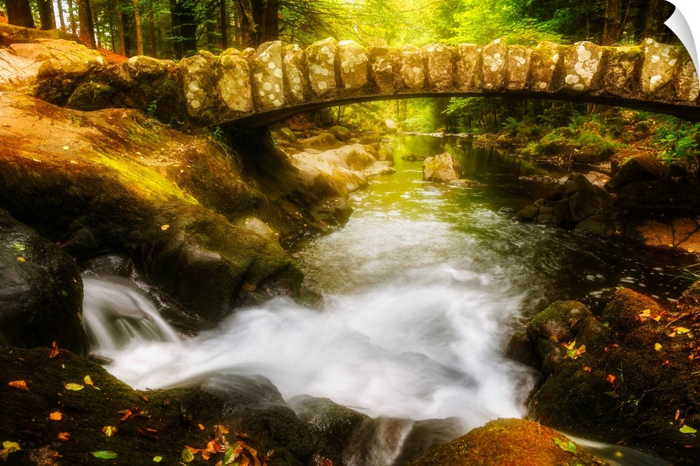 Old stone bridge over the Saut des Cuves (Waterfall of the Holes) in the forest near Gerardmer, France.