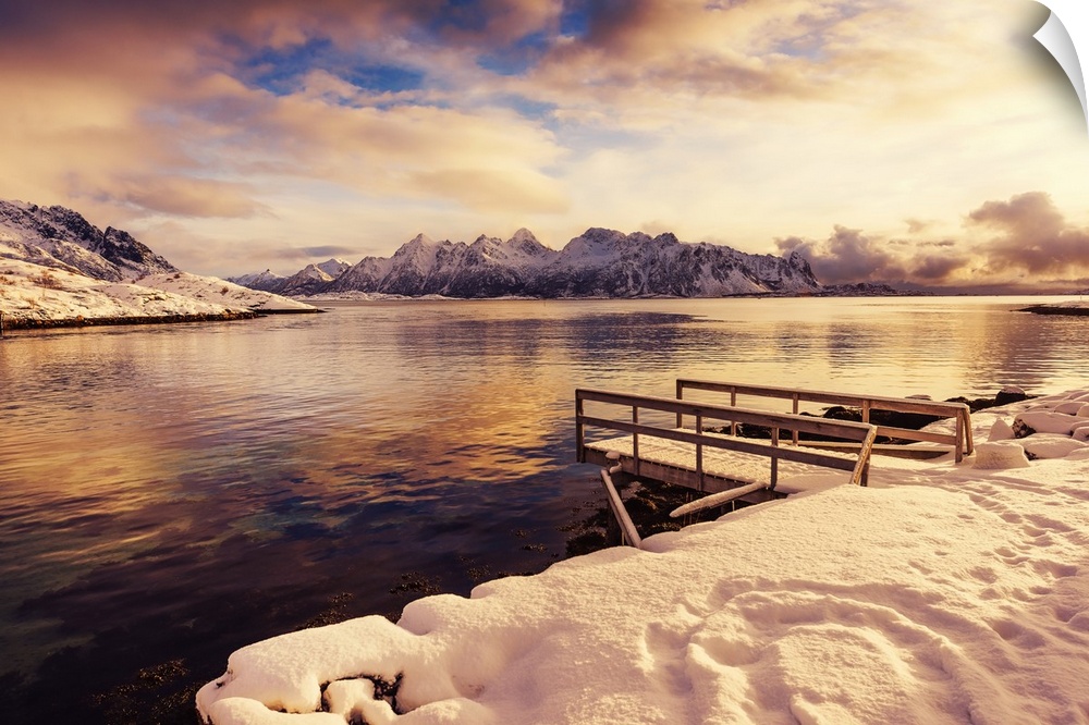 A photograph of a mountain range seen from across a lake in winter.