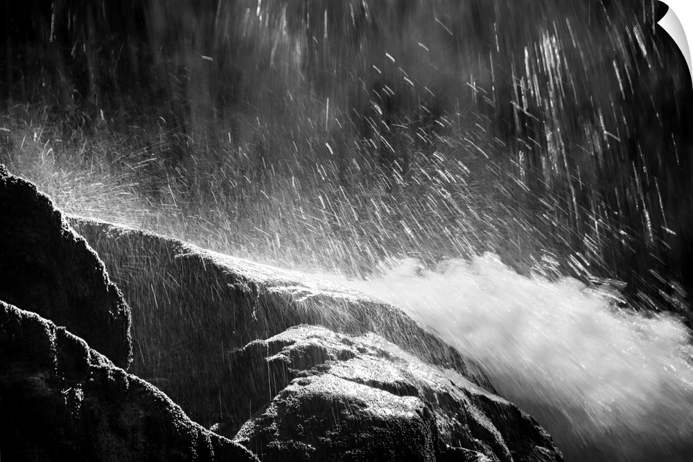 Black and white photograph of water falling from the top and rushing down rocks.