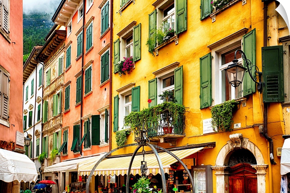 Fine art photo of the brightly colored buildings and window shutters of an Italian street.