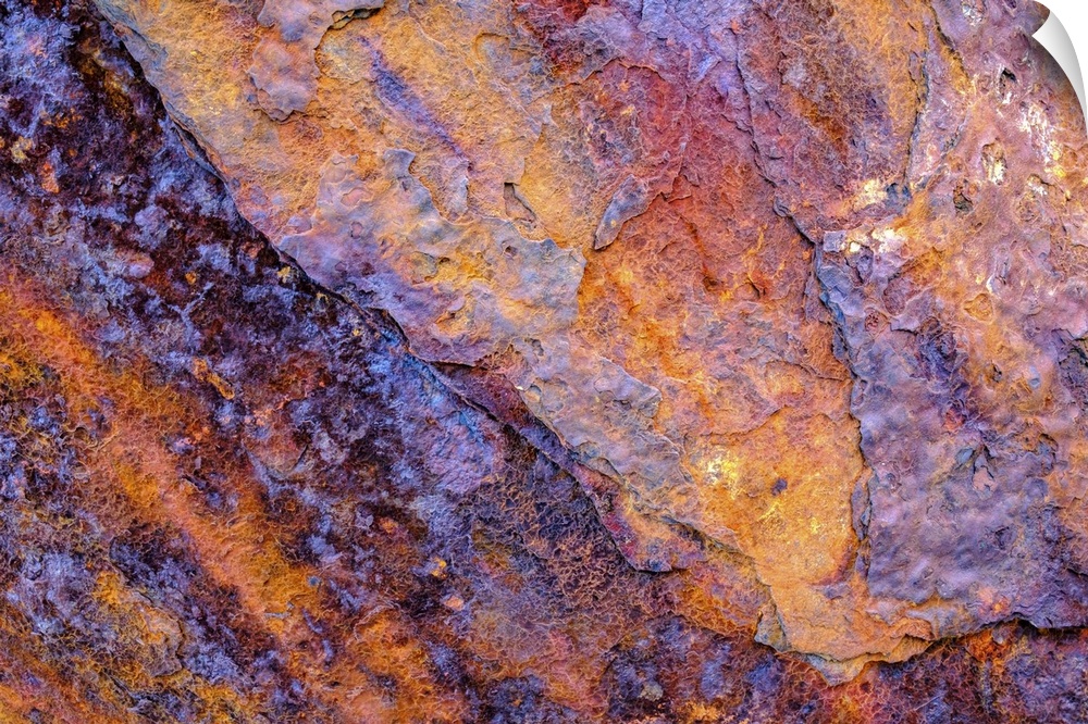 A close-up photograph of a multi-colored rock in purple and orange.