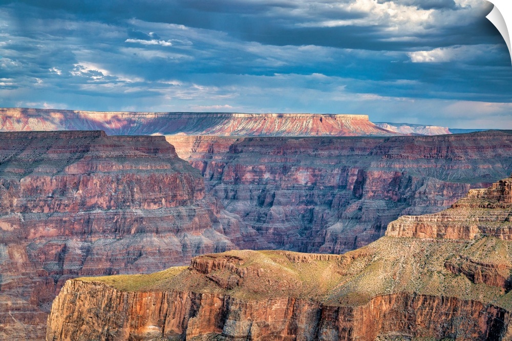 Photograph of a beautiful canyon landscape with a blue, cloudy sky above.