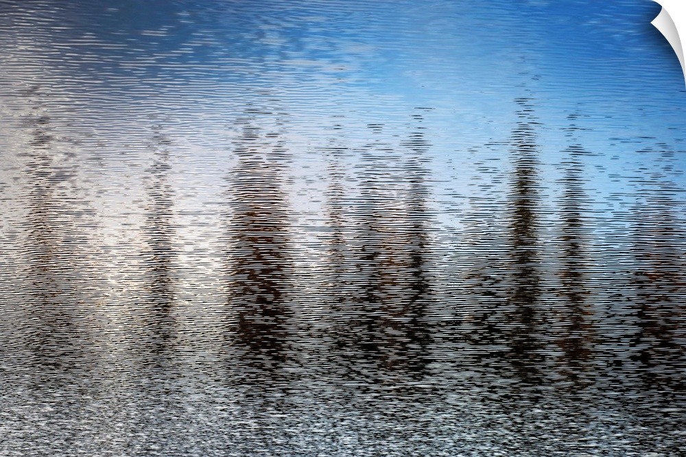 Fine art photo of abstract shapes reflected in the rippling water of a lake.