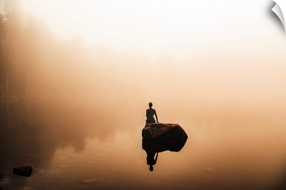 Foggy landscape with the sculpture of a woman reflected in the water