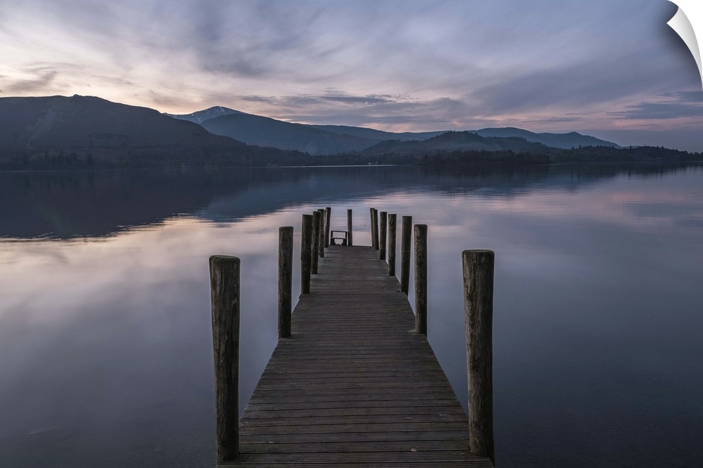 A wooden pier extending into the lake at dusk.