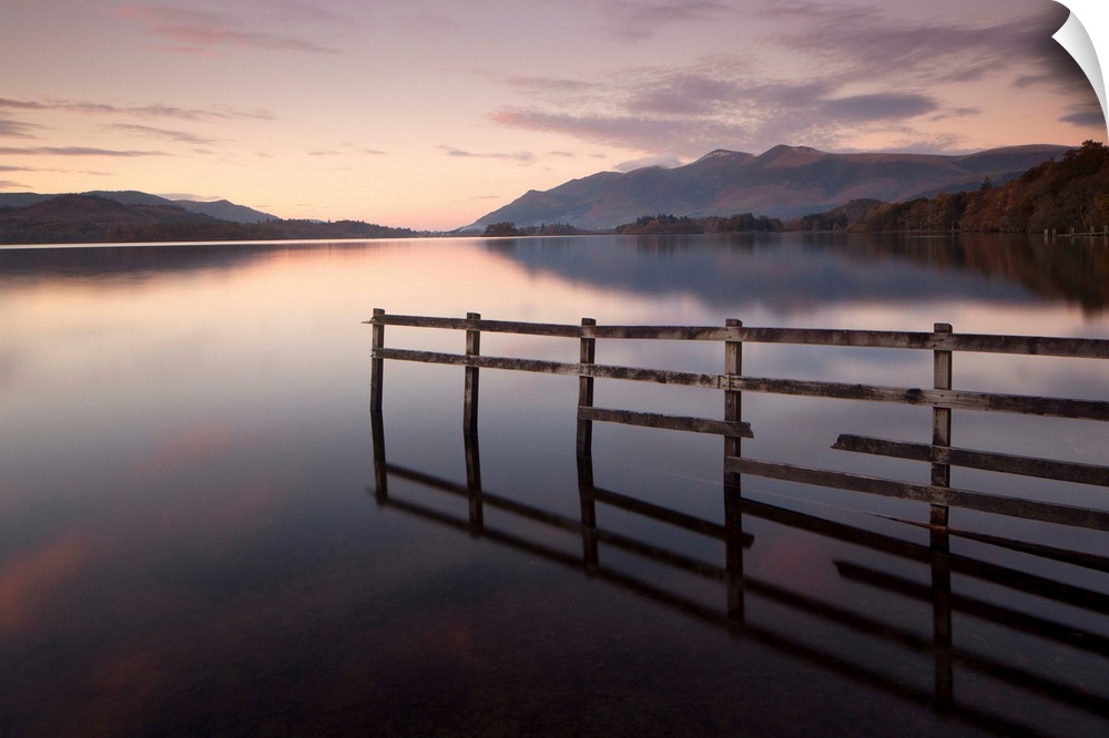 A soft pink dawn over the still Derwent Water in the English Lake District, Cumbria.