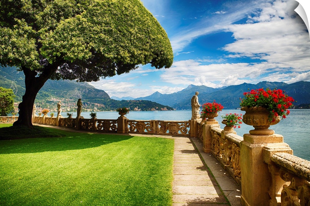 Potted plants in stone vases on a terrace at the edge of Lake Como, Italy.