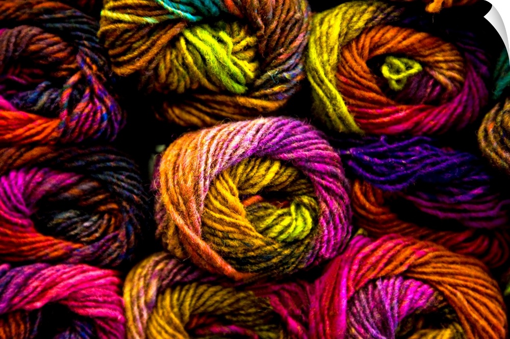 A close up of richly coloured knitting yarns in a kaleidescope of colours.