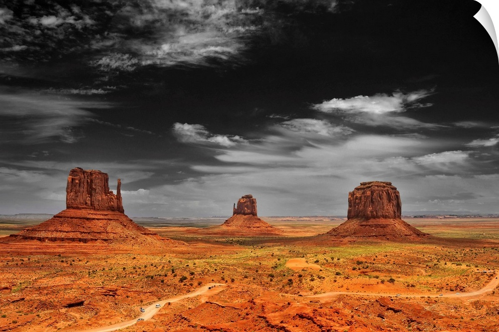 Photograph taken of an immense desert with the sky in black and white and the terrain in color.