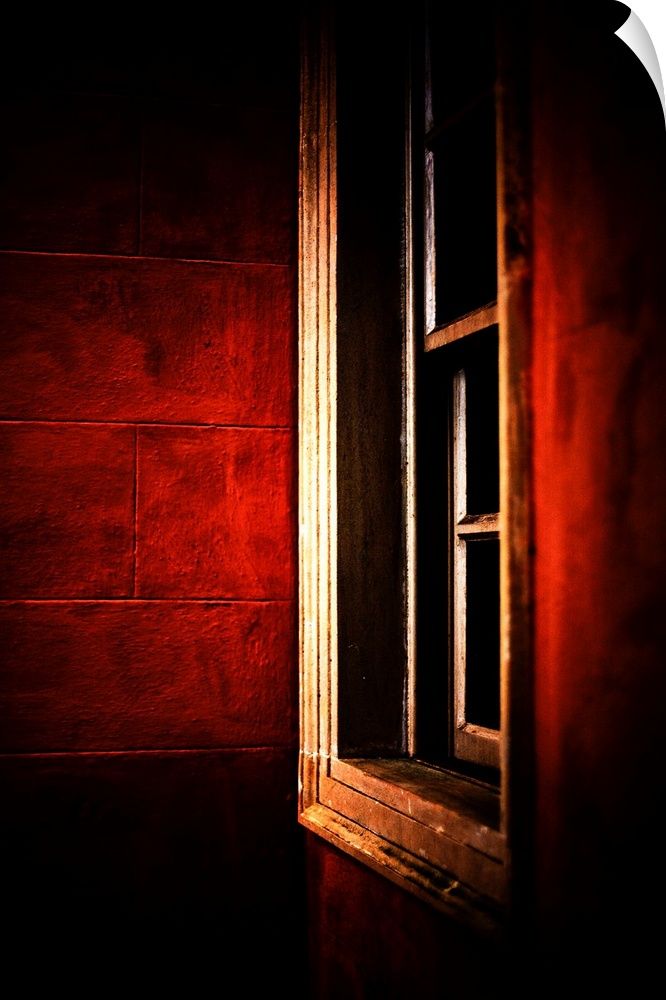 A white framed window set at an angle in walls of deep glowing crimson red.