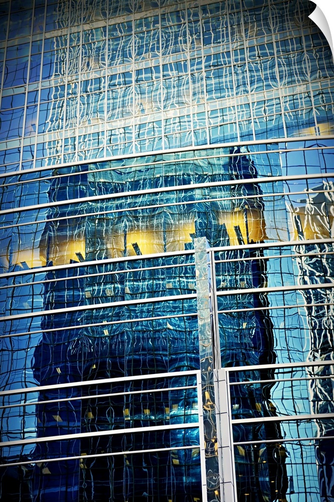Warped and curved reflection of a tall building seen in the windows of a neighboring skyscraper, creating an abstract image.