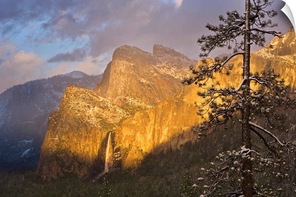 Large canvas photo print of big rugged mountains with a waterfall highlighted with the warm colors of a setting sun.