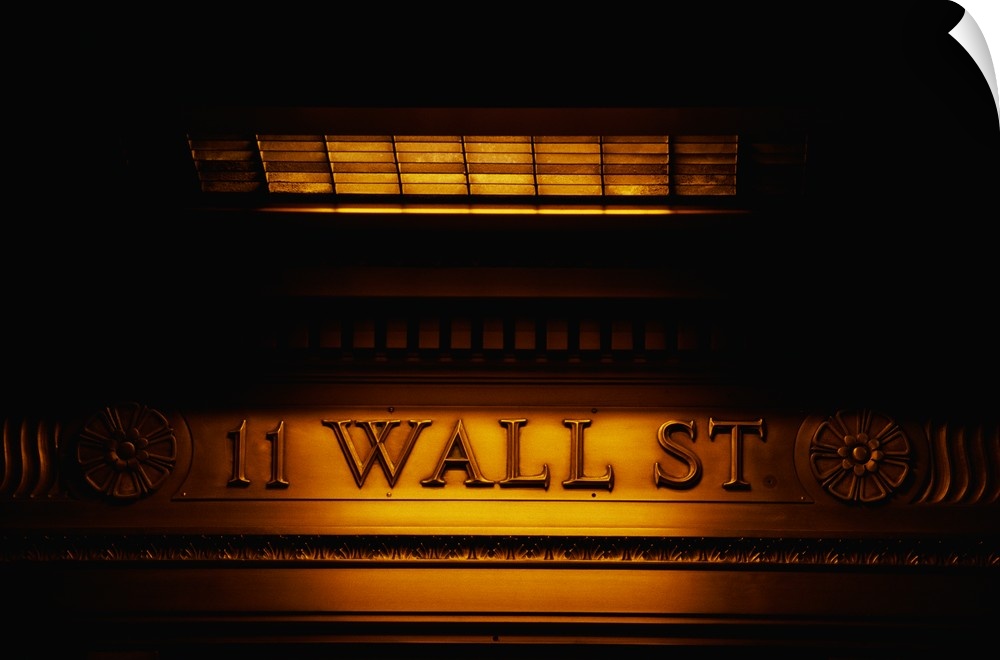 Large canvas photo of an engraved financial district sign that is dimly lit around its edges.
