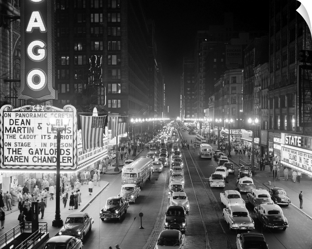 1950's 1953 Night Scene Of Chicago State Street With Traffic And Movie Marquee With Pedestrians On The Sidewalks.