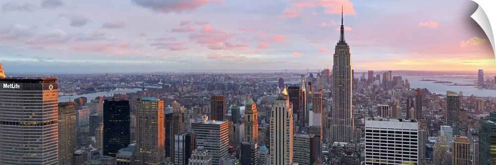 Panoramic canvas of the NYC cityscape seen from above with a beautiful sunset and views of the water in the distance.