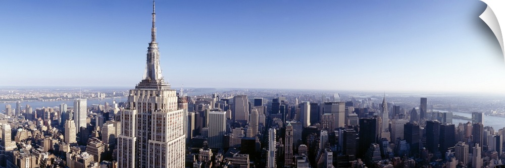 A high angle photograph of the NYC skyline with the Empire State building in the foreground towering over the skyscrapers.