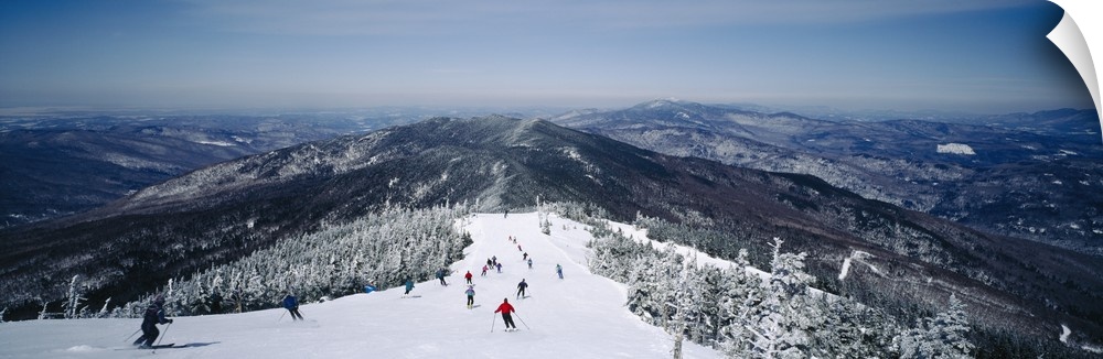 This is a panoramic photograph of skiers heading down a mountain covered with powdery snow in the Appalachian Mountains.