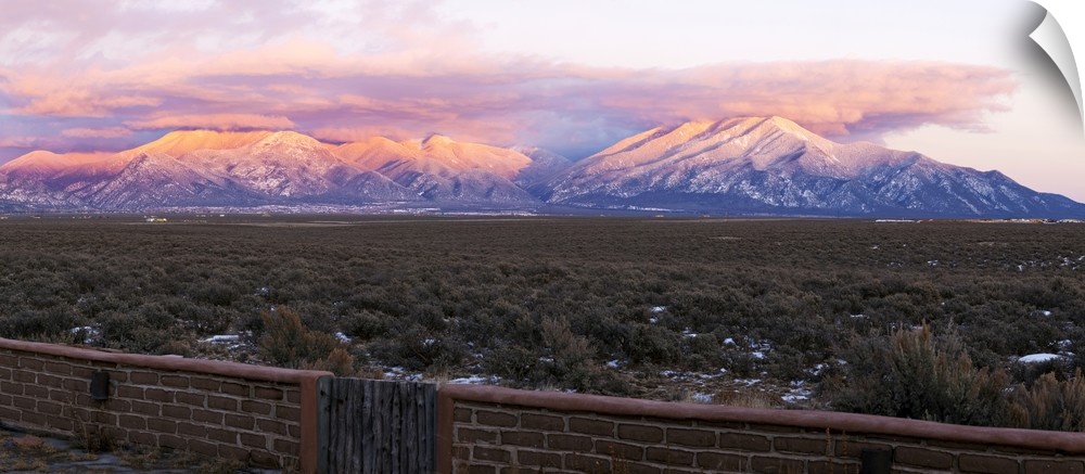 Mountain range viewed from an adobe brick wall and Sangre De Cristo Mountains, New Mexico, USA.