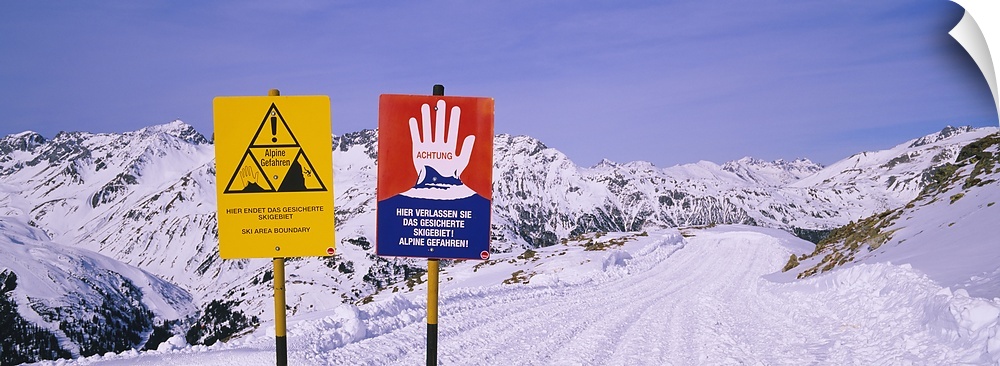 Avalanche warning signs on snowcapped mountains, Rendl Ski Area, St. Anton, Austria