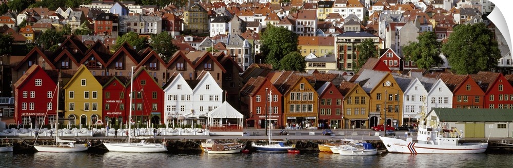 This is a panoramic photograph of a coastal town in Northern Europe lining a harbor full of boats.