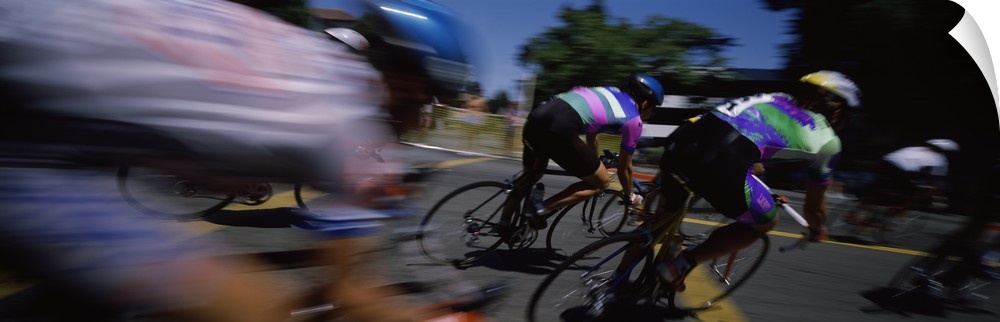 Panoramic blur motion photograph of cyclists racing on the street.