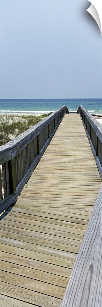 Wooden walkway leading down to the sand and dune grass, the waters of the Gulf of Mexico in the background.