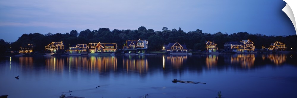 Panoramic photo of Boathouse Row in Philadelphia, Pennsylvania (PA) at sundown. Lights on the houses are reflected in the ...