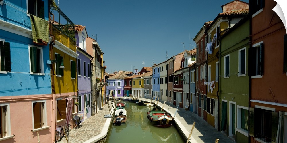 Colorful buildings line either side of a canal in Italy.