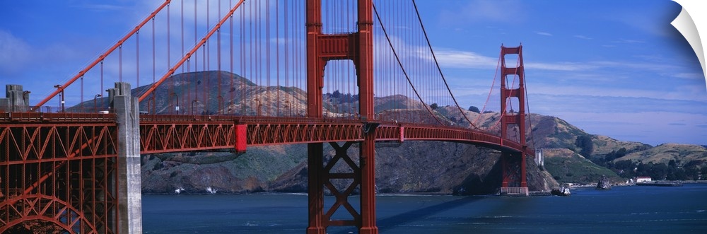 Panoramic photo featuring an angled view of the Golden Gate Bridge over the Pacific Ocean in San Francisco, California.