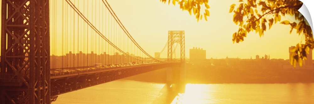Panorama photograph taken of the George Washington bridge during sun down which gives the picture a golden hue.