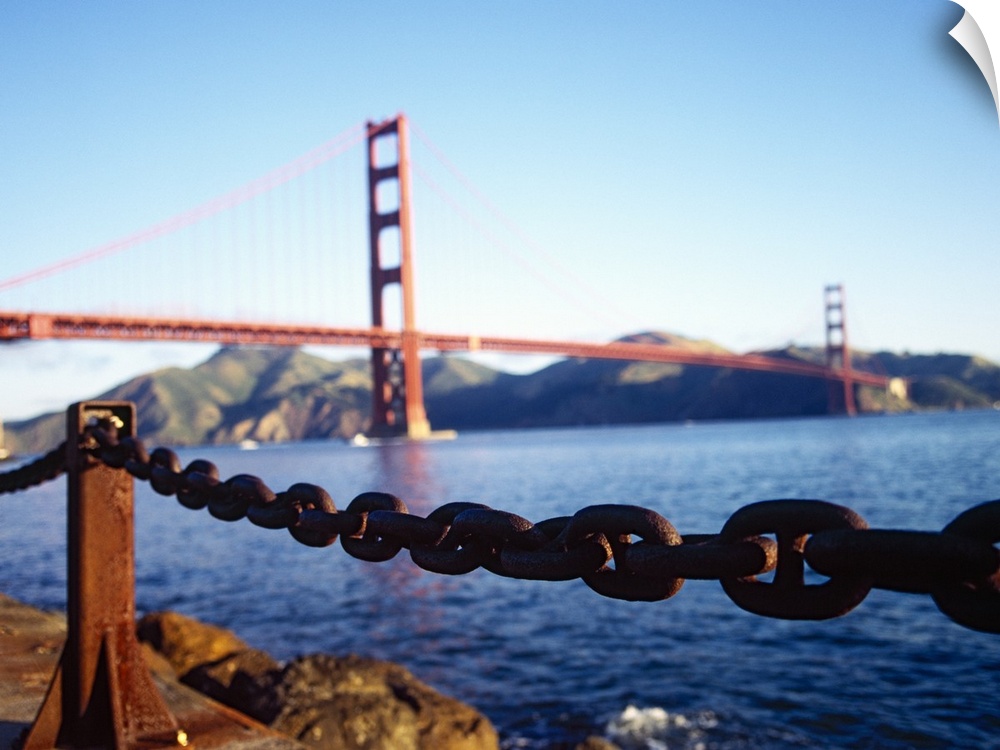 Large, landscape photograph of a chain running on the top of a retaining wall near the San Francisco Bay, the Golden Gate ...