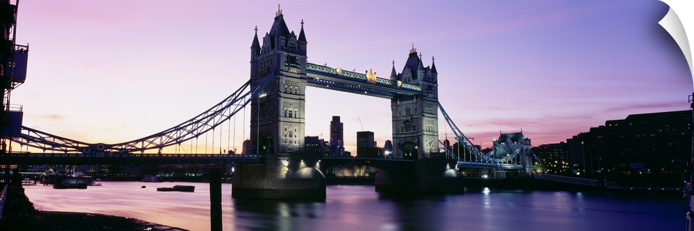 Panorama of the Tower Bridge at dusk with color reflections in the Thames River of London, England.