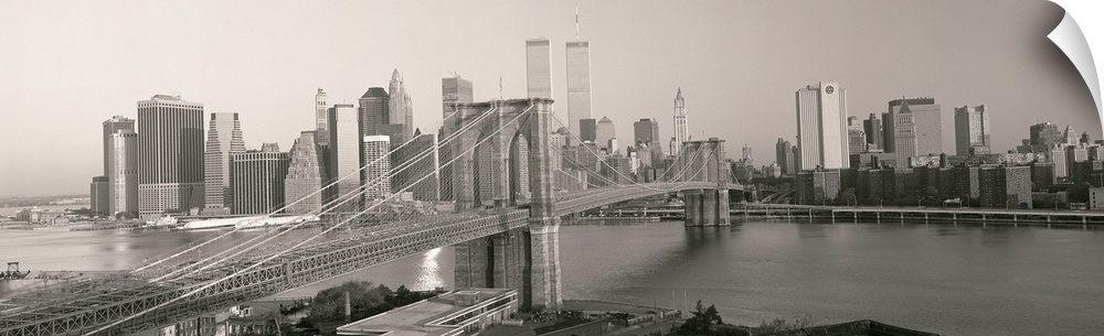 Panorama of Manhattan skyline and the Brooklyn Bridge in black and white and grayscale tones.