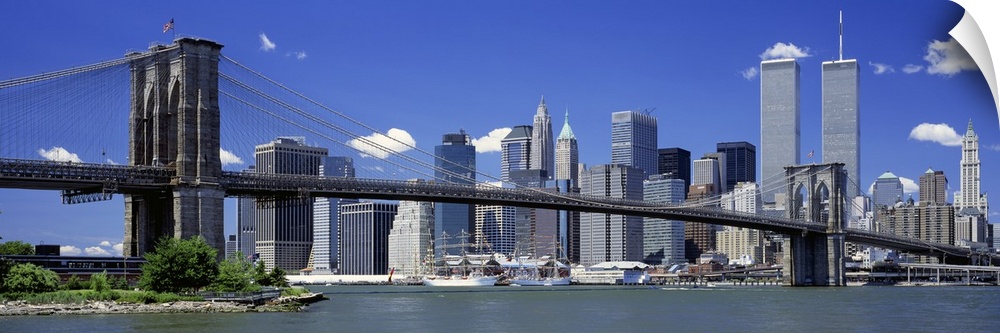 The World Trade Center buildings rise over the city skyline near the large suspension bridge in the famous United States c...