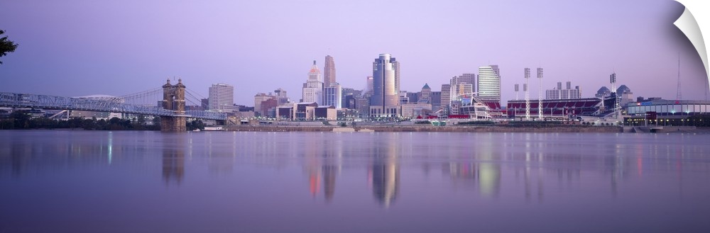 A wide angle photograph is taken from across the river of the skyline in Cincinnati during the evening.