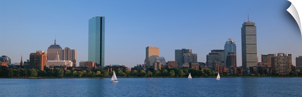 Panoramic photo on canvas of buildings lining a waterfront with three sail boats sailing.