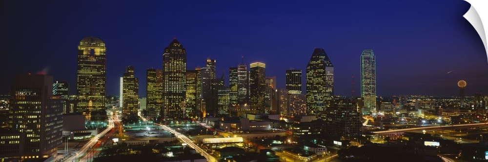 Panoramic photograph showcases the busy skyline of Dallas, Texas as it shines at night.