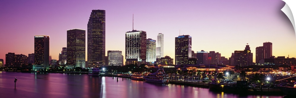 Panoramic photo of the city skyline lighting up as the sun sets  in Miami, Florida.