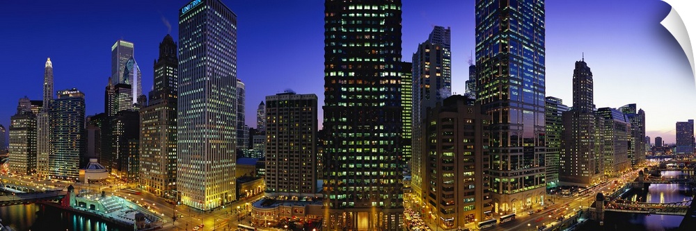 Panoramic photograph of skyline with buildings and streets glowing in night sky.