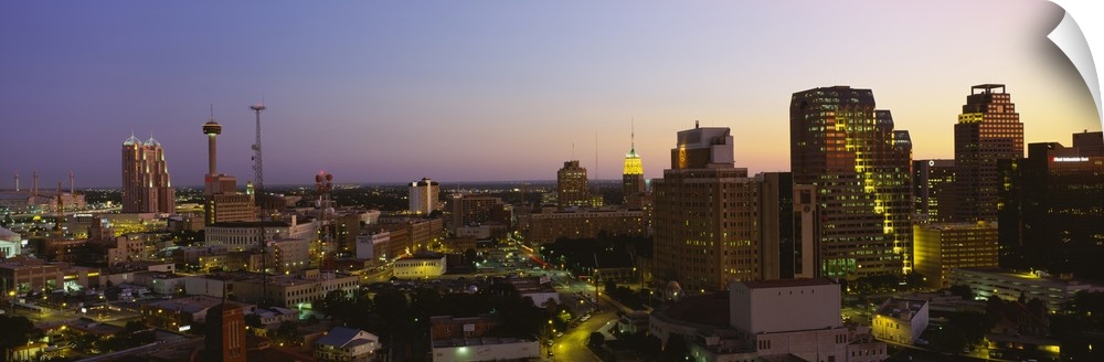 Big panoramic view of the San Antonio skyline lit up while the sun is setting.
