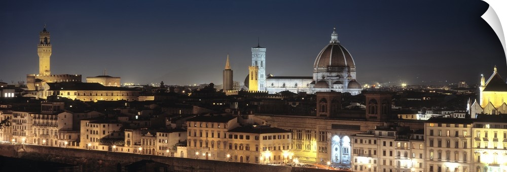 Long and horizontal photo on canvas of the cityscape of Tuscany illuminated at night.