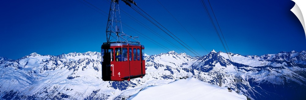 An aerial tramway overlooking the snowcapped mountains in Andermatt, Switzerland.