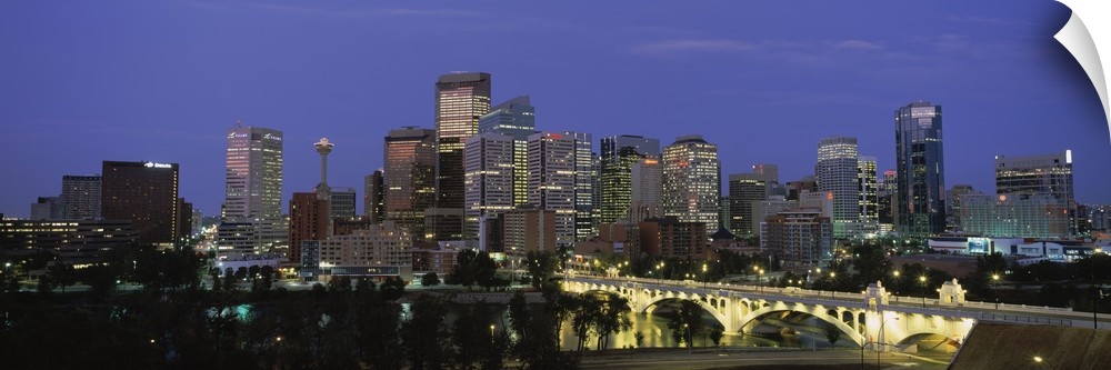 Panoramic image of downtown Calgary lit up at dusk.