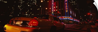 Car on a road, Radio City Music Hall, Rockefeller Center, Manhattan, New York City, New York State