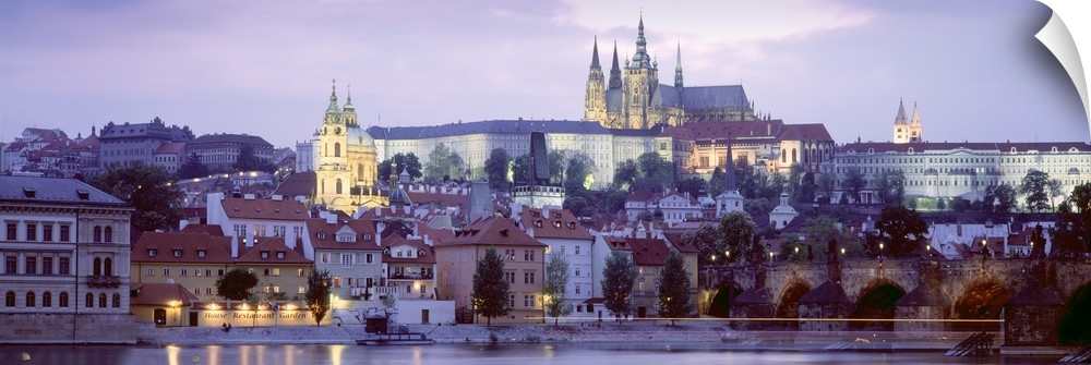 Wide angle photograph of buildings in Prague, Czech Republic, lit up at night, including Hradcany Castle.