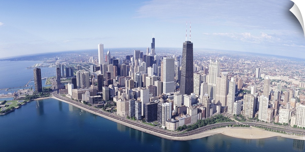 Large, landscape aerial photograph of the large city of Chicago, Illinois, surrounded by calm blue waters.