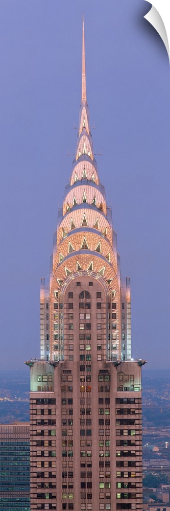 Lit up spire and top floors of the Chrysler building at dusk.