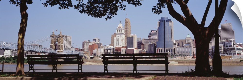 Giant, wide angle photograph of two park benches looking toward the Cincinnati skyline in Ohio.
