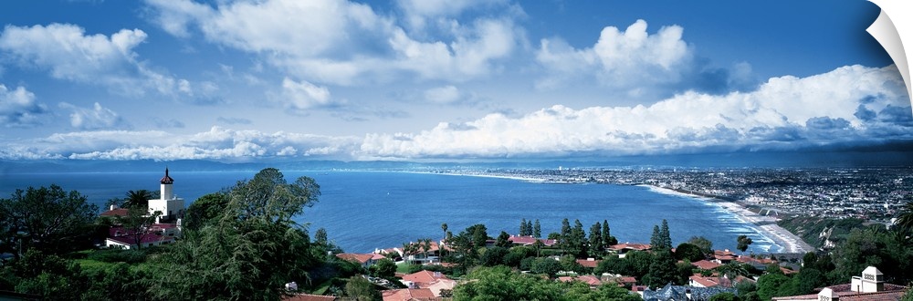 Large panoramic print of a city along the Pacific Ocean with big billowing clouds in the distance.